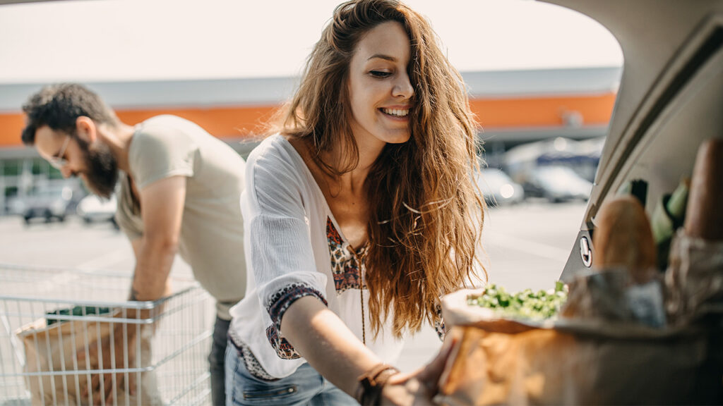 young couple loading groceries in a car