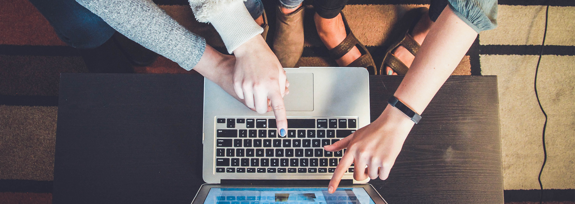 hands pointing at computer screen