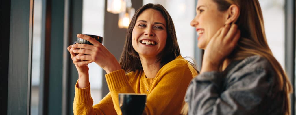 two women in coffee shop smiling