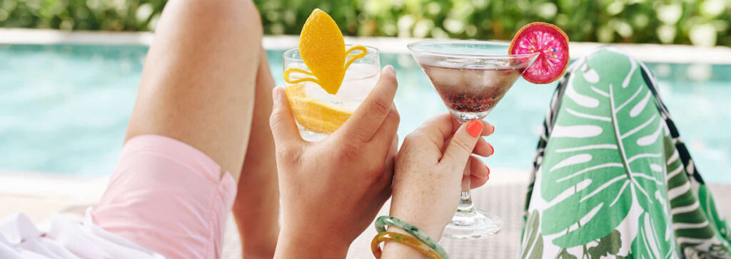 couple by pool with drinks