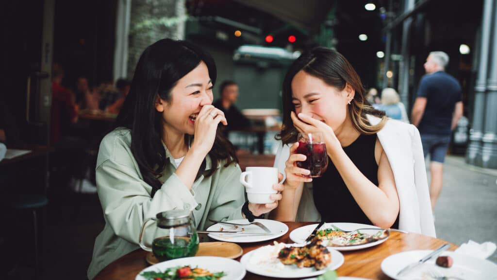 two friends laughing at dinner