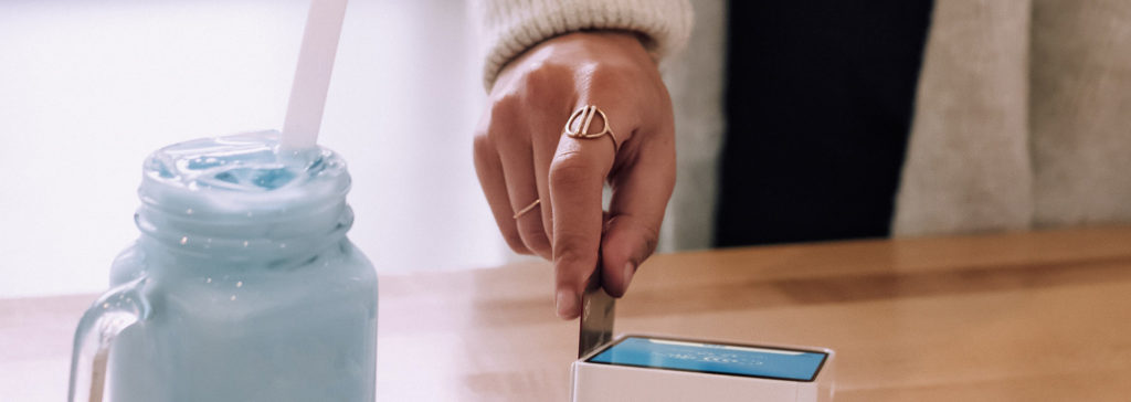 hand swiping credit card at cafe