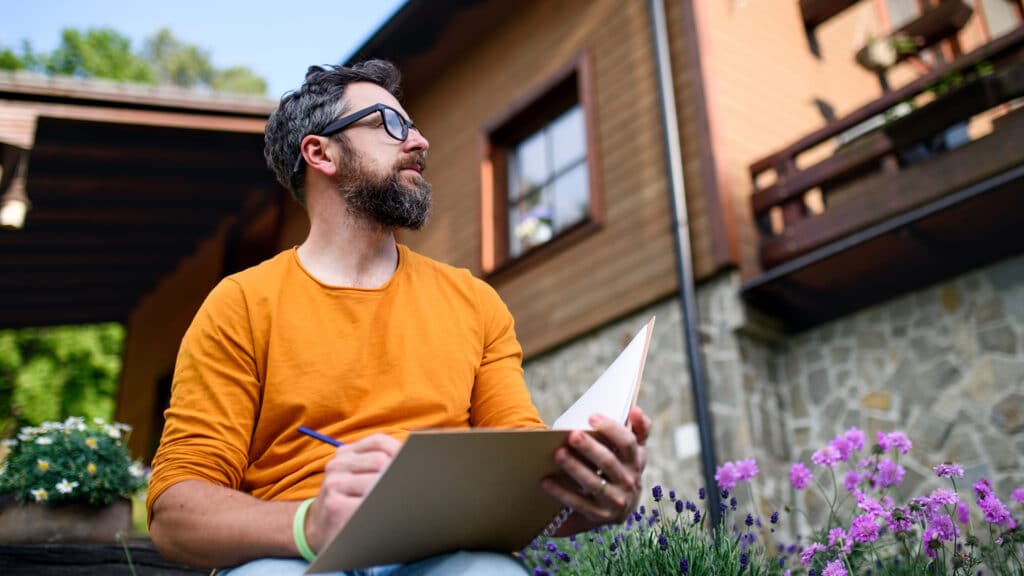 man sitting in front of home