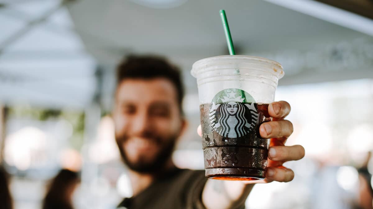 man holding starbucks coffee