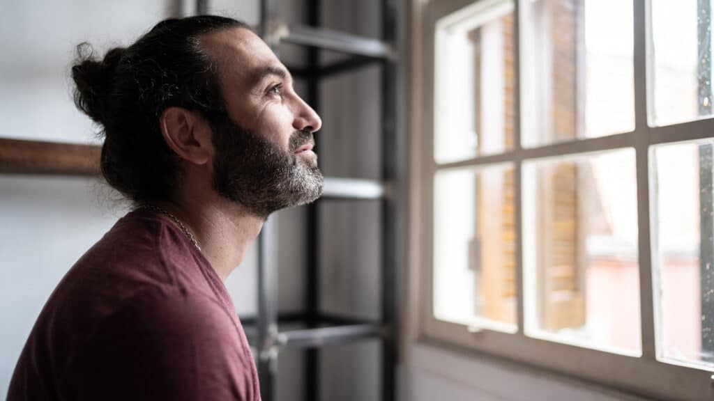 man thinking on a decision by window