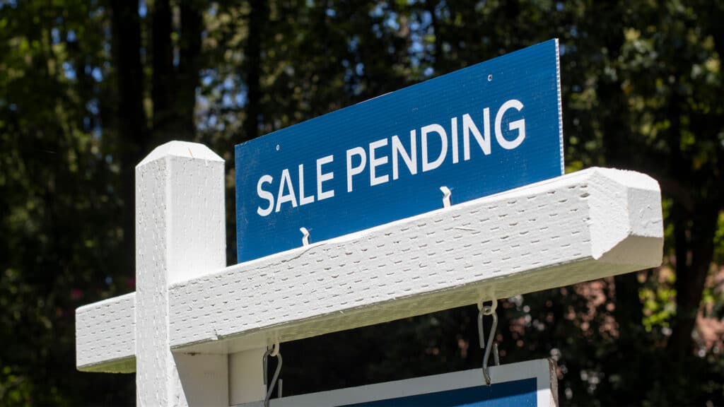 Sale pending sign in front of house