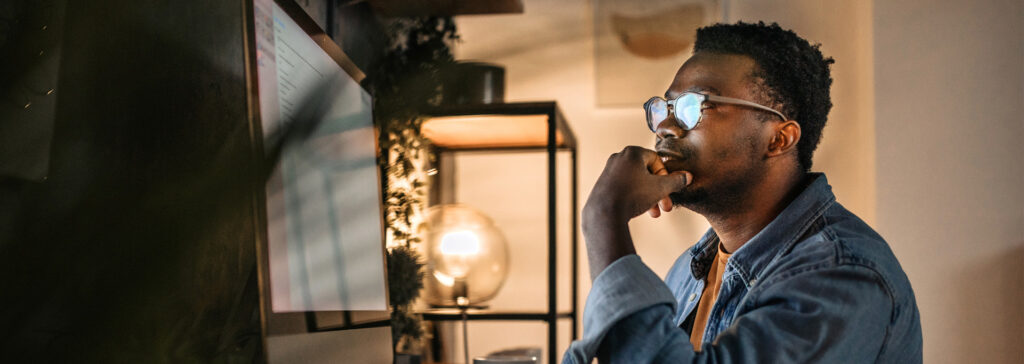 man in home office on computer at night