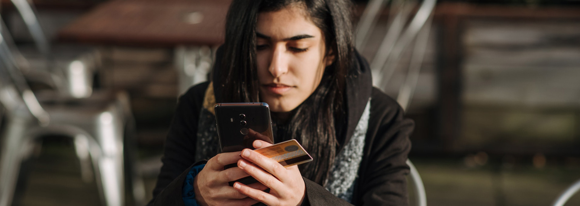 woman on phone checking credit card bill