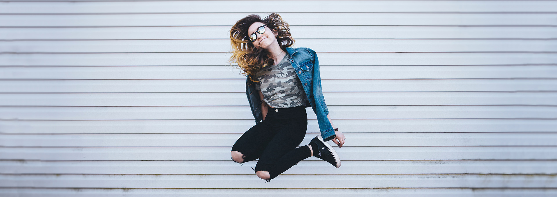 girl jumping in front of white wall