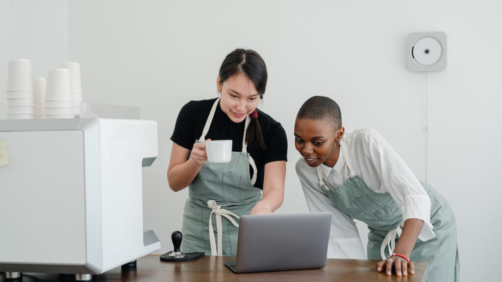 workers in coffee shop on computer