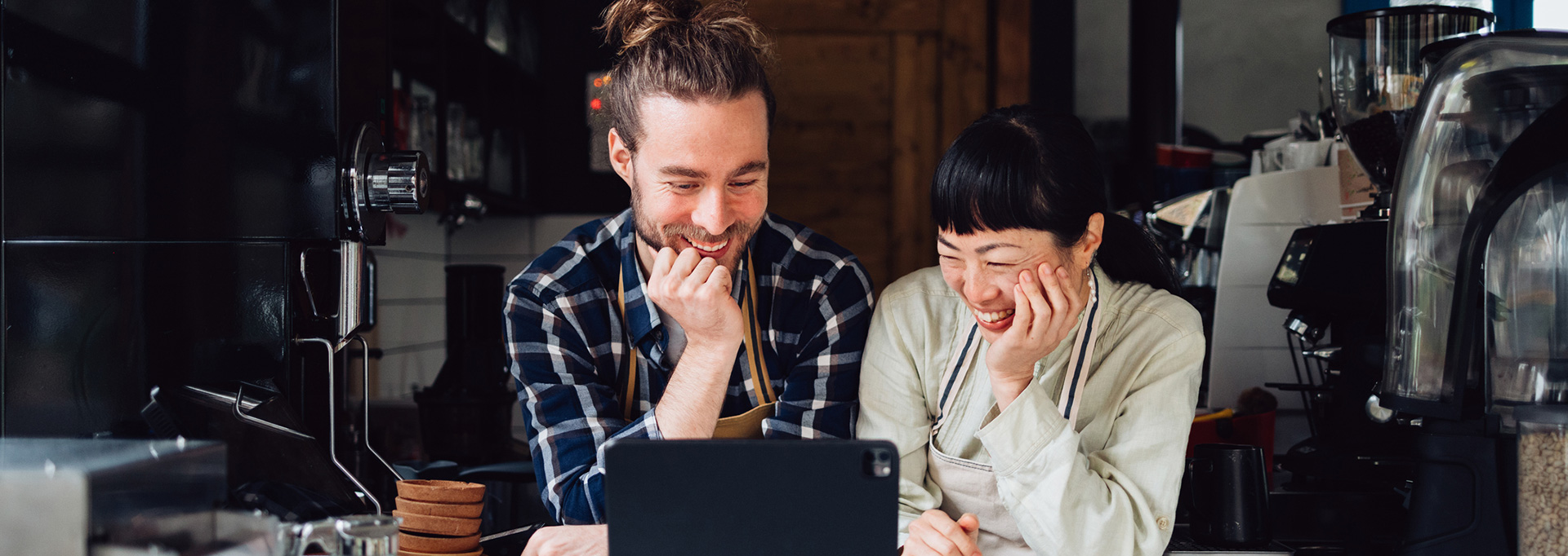 small business owners looking at computer in cafe