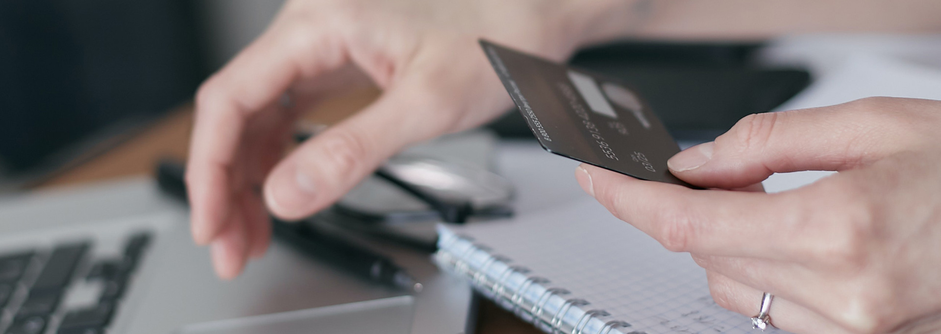 hand holding credit card at the computer