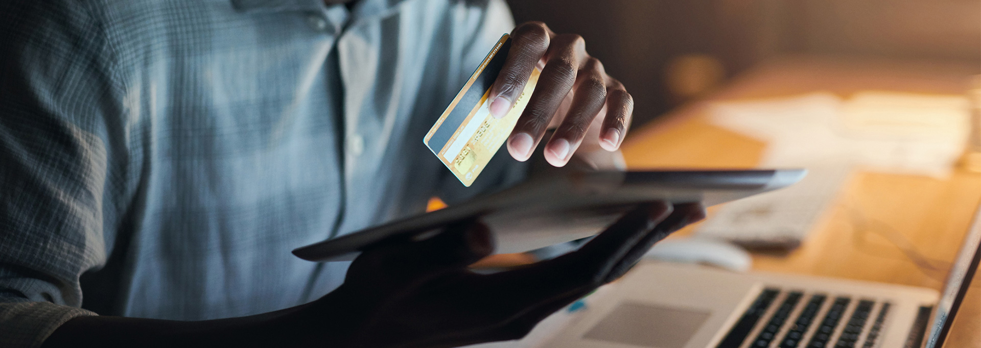 man holding credit card at computer