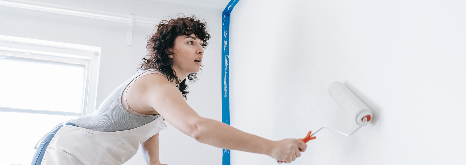 woman painting walls in home