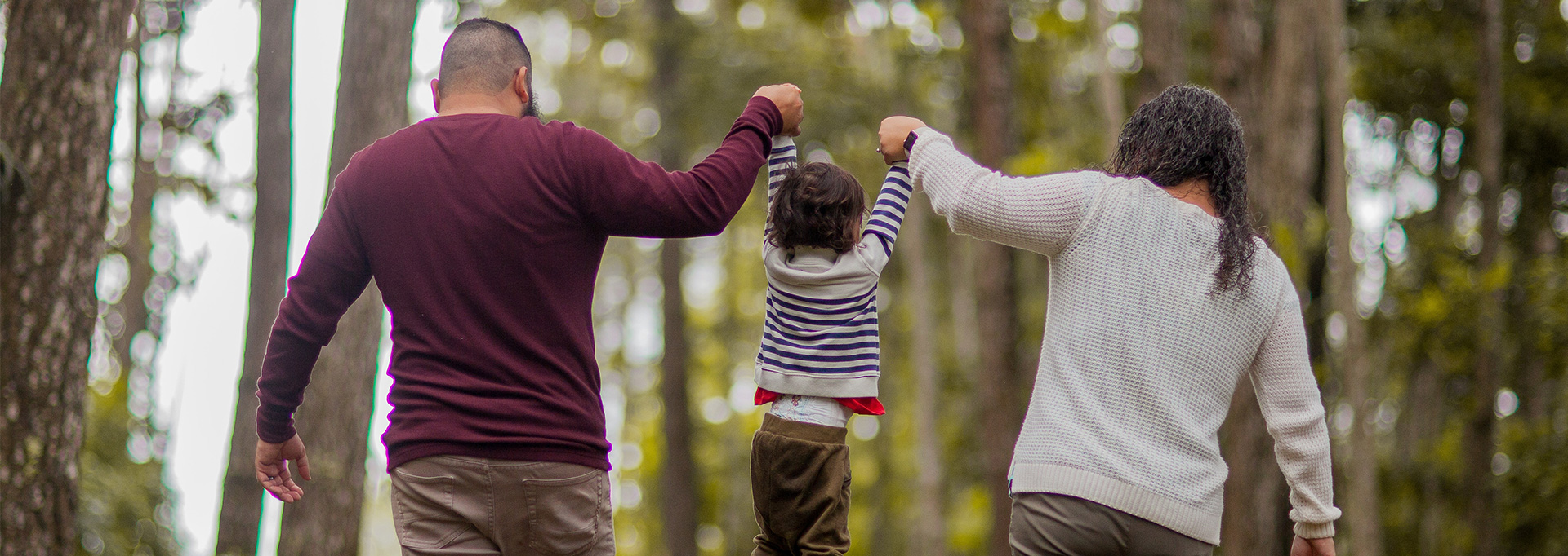 parents walking with child in woods